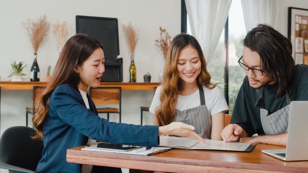 Asian small business owners couple meeting with consultant talking about business plan.